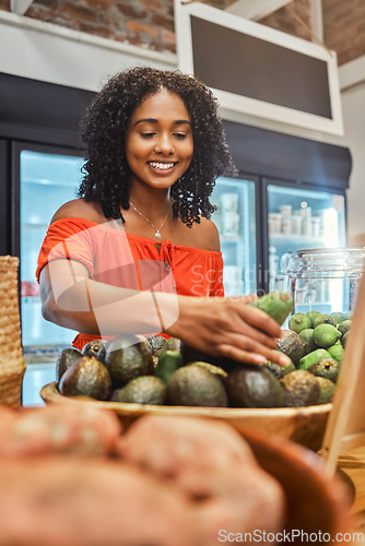 Image of Black woman at supermarket, grocery shopping and avocado, customer and retail, vegetable fresh product and buying food at store. Young, African American and smile, sale and discount on groceries.