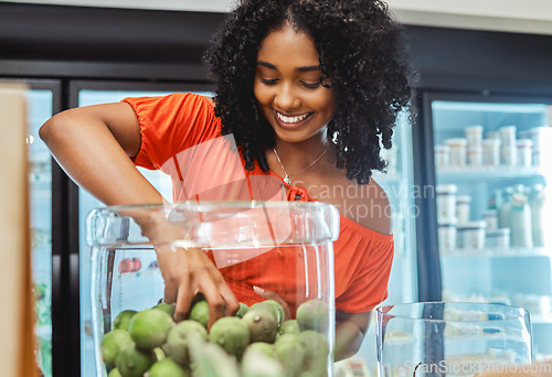 Image of Black woman, grocery store and shopping, hand in jar and fruit to buy, customer and fresh product at local supermarket. Food, retail and sale, shop organic and young African American female in store.