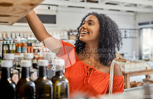 Image of Supermarket, shelf and shopping customer woman retail store for eco friendly product, olive oil or groceries choice. Happy woman in small business store marketplace with choice or food sale discount