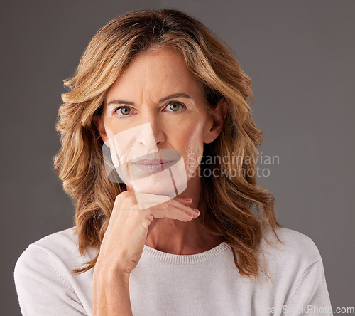 Image of Face, beauty and skincare with a senior woman looking serious in studio on a gray background. Cosmetics, antiaging and treatment with a mature female pensior posing to promote a health product