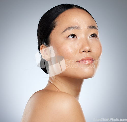 Image of Beauty, asian and woman skincare with natural face thinking or contemplating with beautiful glow. Cosmetic hydration advertising for healthy skin with thoughtful model girl on grey studio mockup.