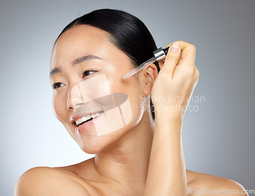 Image of Asian woman beauty, facial serum and essential oil, aesthetic dermatology and skincare on studio background. Happy Japanese model face, wellness and liquid makeup, hyaluronic acid and body cosmetics