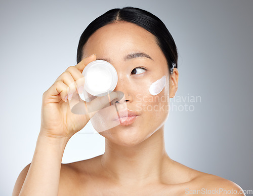 Image of Face, beauty and skincare with a model asian woman in studio on a gray background to promote a product. Wellness, luxury and facial with an attractive young woman posing for cosmetics or health