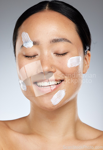 Image of Beauty, face and skincare with a model asian woman in studio on a gray background for health or wellness. Cosmetics, antiaging and healthy with an attractive young female posing to promote a product