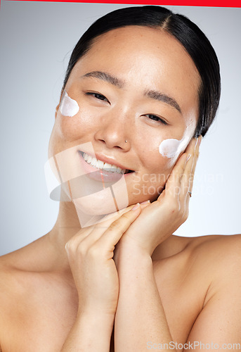 Image of Skincare, beauty and Asian woman with cream on face, smiling in studio on white background. Wellness, skincare products and portrait of happy girl with sunscreen, lotion and beauty product for facial
