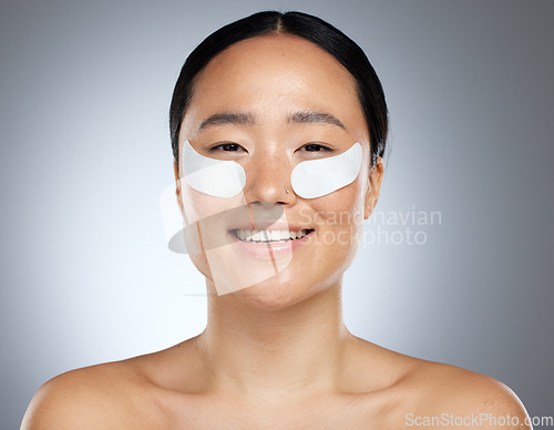 Image of Beauty, asian and portrait of woman with patch for eye collagen skincare with happy smile. Satisfied girl model with face cosmetic treatment for skin anti aging with grey studio mockup.