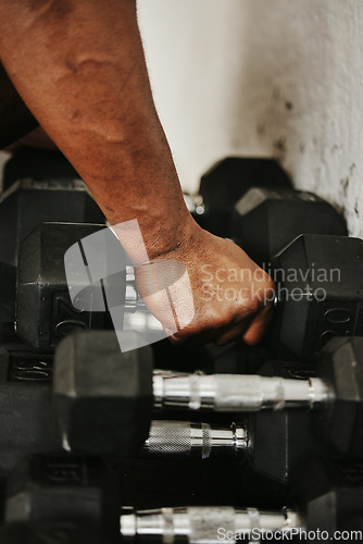 Image of Hand, dumbbell and fitness with a man bodybuilder in a gym for exercise, training or a workout with weights.