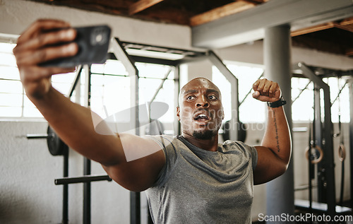 Image of Gym selfie, smartphone and man flexing arm muscle for a post gyming pump bodybuilding exercise for online social media. Black man, fitness workout trainer and bodybuilder training for wellness health