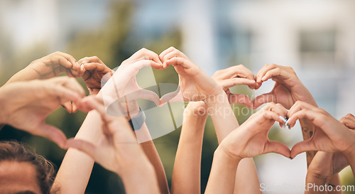 Image of Hand, heart and love with a group of people making a sign with their hands outdoor together in the day. Crowd, freedom and community with man and woman friends doing a gesture to promote health