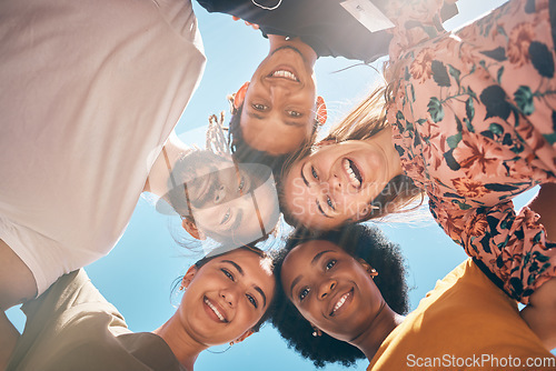 Image of Friends, diversity and huddle with a man and woman group standing outdoor together on a blue sky in summer. Travel, smile and community with male and female people outside with a smile from below