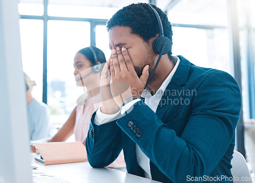 Image of Stress, customer support and call center employee with a headache in a workplace with headset. Customer service, crm and bored African ecommerce sales man with burnout working in telemarketing office