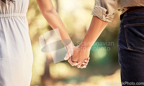 Image of Hand, love and couple with a man and woman holding hands outdoor in care, trust and relationship. Zoom in of a male and female walking outside together for romance and affection with trust in forest