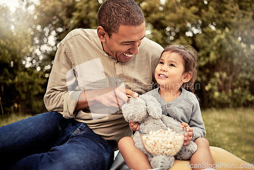 Image of Father, girl and popcorn eating of a happy child and parent outdoor laughing with a smile. Dad, happiness and kid with food hug together with bonding, quality time and nature experience having fun