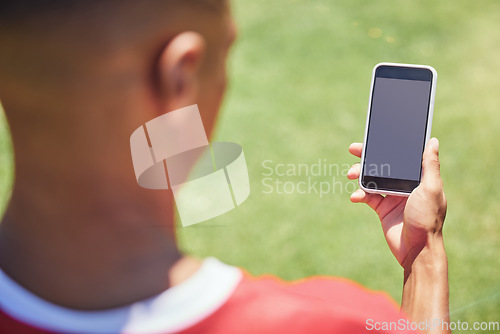 Image of Man, soccer player and phone on field with screen, blank and mockup on the internet. Man, football player and smartphone on social media, web or app at training, game or sport on pitch at contest