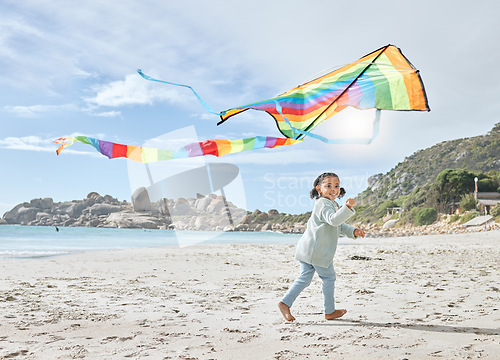 Image of Beach, smile and girl running with kite on holiday, vacation or trip outdoors having fun. Energy, happy and child from South Africa playing with colorful toy airplane on sandy, sea or ocean shore.