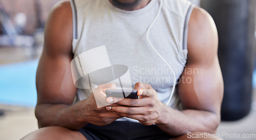 Image of Fitness, hands and phone in gym with man after workout, training or wellness exercise with social media. Strong, muscular and black man text contact, internet or web app in a health and wellness club