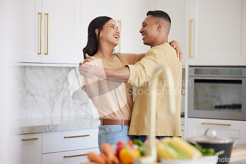 Image of Couple, love and dancing together in kitchen happy at home bonding, spend time and relax. Young married latin man and woman, romance bonding and having fun laughing or celebrate healthy relationship