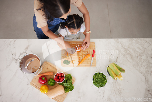 Image of Cooking, vegetables and mom with child in kitchen cutting, peeling and prepare food. Child development, helping hands and aerial view of mother teaching girl to cook, chef skills and bond together