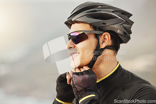 Image of Fitness, sports and cyclist checking his helmet before cycling, training, workout and cardio ride in nature. Health, biking and athletic man getting ready for cycle, happy, smile and relaxed training