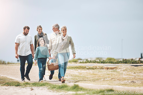 Image of Big family, happy and walking for a picnic on holiday, vacation or weekend trip outdoors for relaxing and bonding. Mother, father and grandma travel with old man and girl child to enjoy quality time