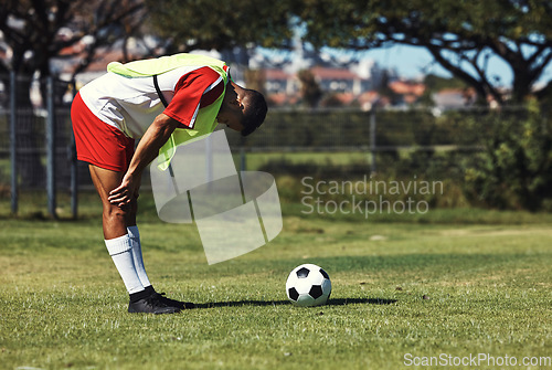 Image of Man, tired and soccer ball on field in training, warmup or workout outdoor in summer. Exercise, soccer player and rest by football on grass in sunshine for sport, health or performance in development