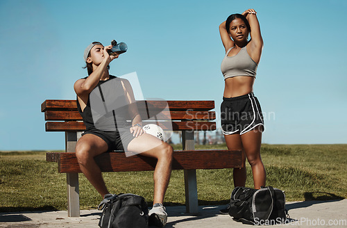 Image of Man, woman and fitness break for stretching, drinking water or muscle recovery after training, exercise and workout. Soccer players, sports friends or football players in warmup in nature garden park