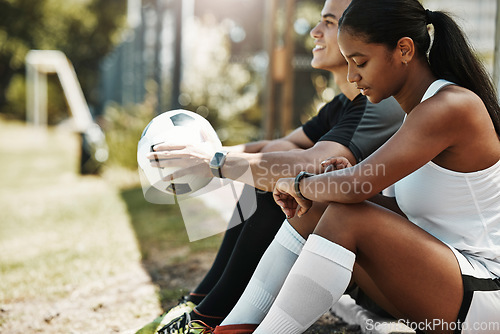 Image of Fitness, smartwatch and soccer couple check time, pulse and heart rate with technology after exercise, training or practice. Man, woman or rest with football, cardio or sport workout outdoor on field