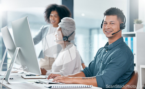 Image of Call center, customer service and telemarketing consultant man and diversity team working in crm office. Contact us, teamwork and support male employee typing on pc and wearing headset for support