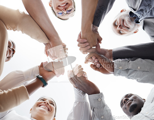 Image of Hands, teamwork and motivation with a business team in a huddle or circle together from below. Collaboration, success and community with a man and woman employee group standing hand in hand in unity