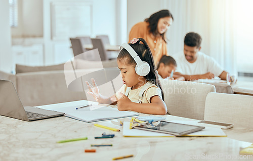 Image of Child, hand and counting at desk with book for math, homework or education in home with family. Girl, laptop and fingers with headphones, computer or notebook for development in homeschool at table