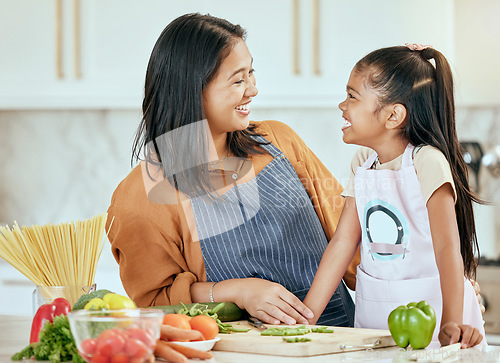 Image of Happy family, mother girl cooking food for a healthy vegan diet with spaghetti and vegetables at home. Smile, development and child loves helping mom or mama in the house kitchen with lunch or dinner