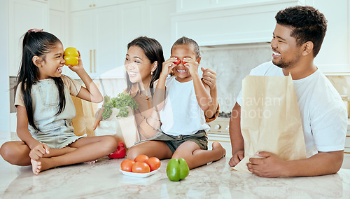 Image of Asian, vegetables and family in kitchen for playing at table, happy or together for bonding. Mom, dad and children with smile at counter for health, food or nutrition with bags after shopping in home