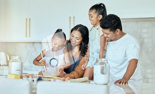 Image of Happy, mother and father baking with children for family bonding, learning and teaching in the kitchen at home. Mama, dad and little girls helping parents with smile for mixing ingredients together