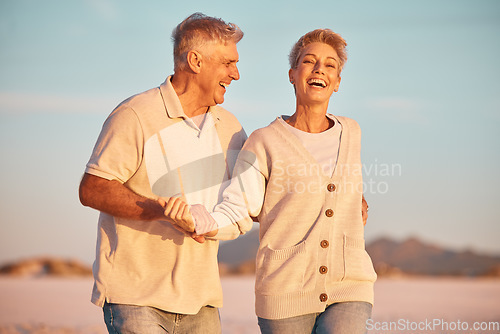 Image of Retirement, couple and being playful outdoor, walking or on beach being loving, together or happy marriage. Love, senior man and mature woman with smile, embrace and holding hands and seaside bonding