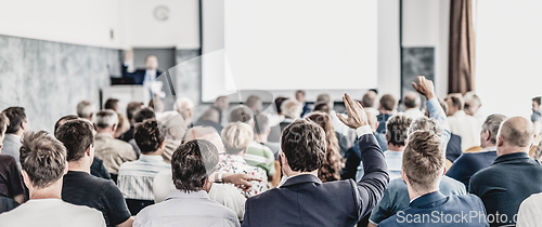 Image of I have a question. Group of business people sitting in conference hall. Businessman raising his arm. Conference and Presentation. Business and Entrepreneurship