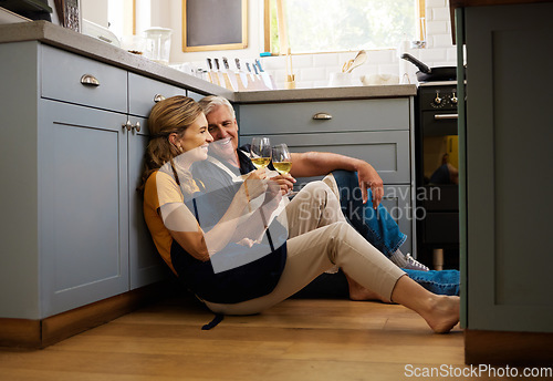 Image of Love, senior couple and on kitchen floor, together and bonding while speaking, talking and with wine. Romantic, retirement or elderly man and woman being loving, romance and anniversary or discussion