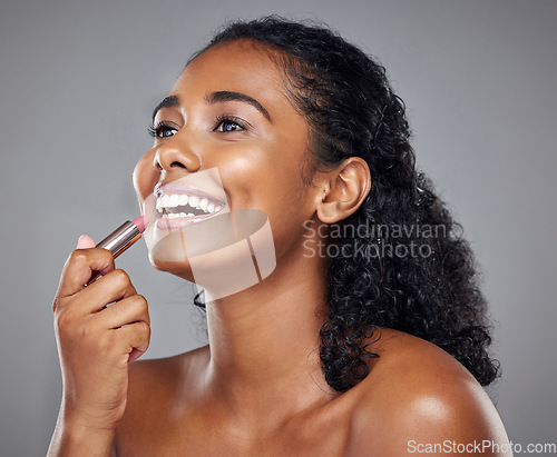 Image of Lipstick, makeup and black woman with smile, thinking and idea against a grey studio background. Happy, young and African model with cosmetics, facial care and dermatology for beauty with a glow