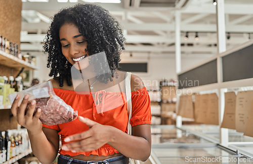 Image of Customer, shopping and woman reading meat label of groceries, stock information and check cost price in retail supermarket store. Happy consumerism choice, healthy food products and grocery quality