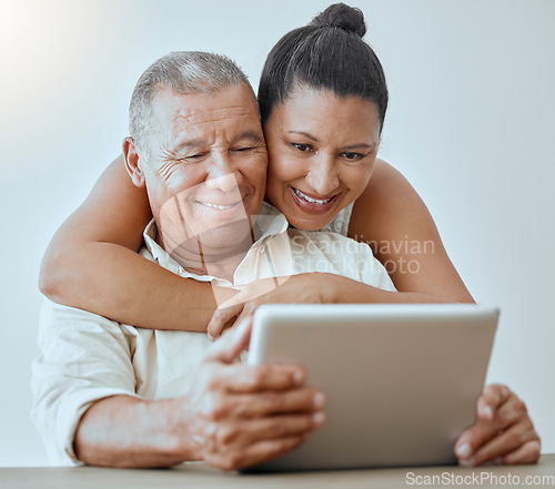 Image of Tablet, internet and love with a senior couple browsing online using wireless technology in the home together. Relationship, smile and happy with an elderly male and female pensioner surfing the web