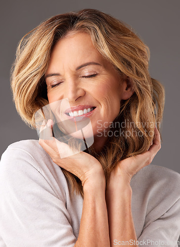 Image of Happy senior woman with natural face makeup, cosmetic skincare beauty and blonde hairstyle in Los Angeles. Elderly lady with wrinkles, elegant modern person and pose in studio on gray background
