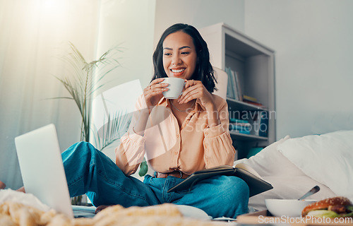 Image of Laptop, coffee and bed with a woman blogger sitting in her bedroom while browsing the internet. Computer, email and drink with a young female freelance employee working from home in the morning