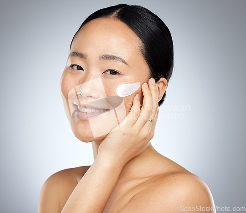 Image of Woman, face cream or grooming skincare routine on studio background for Japanese facial, wellness or luxury healthcare. Zoom, smile or happy beauty model with spf sunscreen product for sun protection