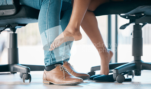 Image of Feet, flirt and affair with a work romance between and business man and woman in the office together. Couple, shoes and love with a male and female flirting under a table at work in infidelity