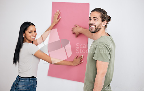 Image of Couple, wallpaper and home, design or renovation with pink poster. Smile, diversity and happy man and woman with banner or paper sheet for decoration, remodeling or renovating in house together