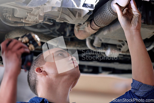 Image of Car, mechanic in garage and service inspection of motor vehicle for maintenance or safety. Auto shop, automobile workshop engineer and repairman working with torch to check vehicle pipe for oil leak