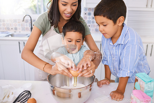 Image of Mom, kids and kitchen for baking, cooking or cake in home while excited, happy or smile on face. Mother, boy and children in house to crack egg for learning of food, cookies or muffins in Los Angeles