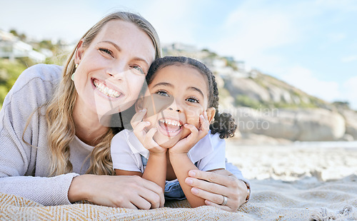 Image of Mom, beach and girl lying for portrait with love, smile or happy for adoption, outdoor or sunshine. Woman, mother and child on blanket at ocean, sand or sea on holiday, vacation or family in summer