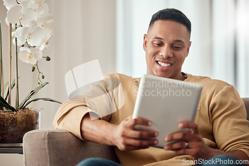Image of Tablet, sofa and black man relax with website information, subscription service or surfing social media app in home living room. Happy man with home technology reading ebook on a digital application