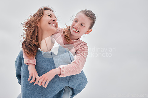 Image of Family, love and piggyback with a girl and mother bonding outdoor in the early morning against a gray sky. Happy, smile and together with a woman and daughter spending time during overcast winter