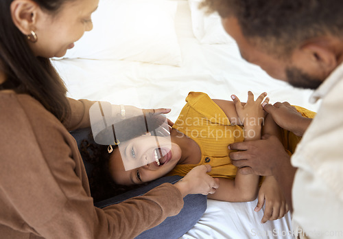 Image of Family tickle, playing and girl with happy parents bonding with quality time together at a home. Laughing, smiling and happiness of a child smile with a mom, father and care on a bedroom bed